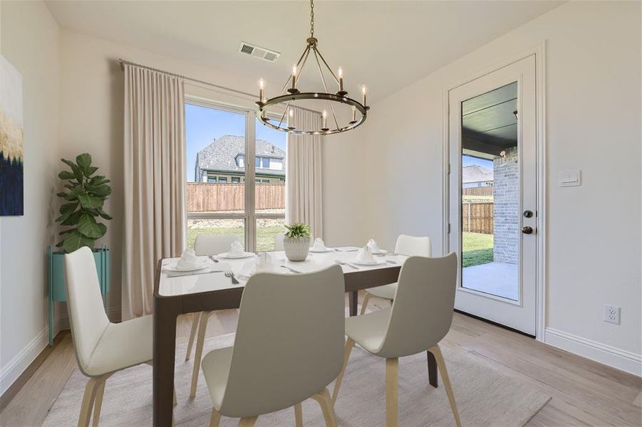 Dining area with a chandelier and light wood-type flooring