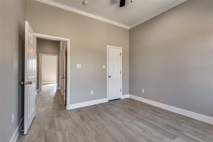 Unfurnished bedroom featuring crown molding and light hardwood / wood-style floors