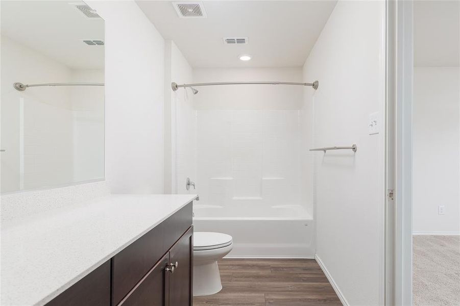 Full bathroom featuring shower / tub combination, hardwood / wood-style flooring, vanity, and toilet