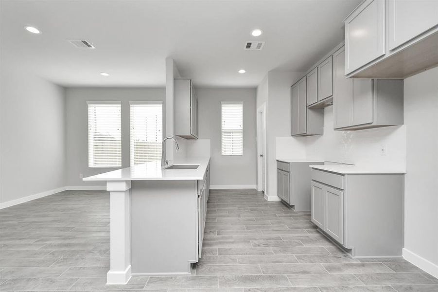 Culinary haven, featuring granite countertops, a tile backsplash, stainless steel appliances (to be installed), and 42” upper cabinets.