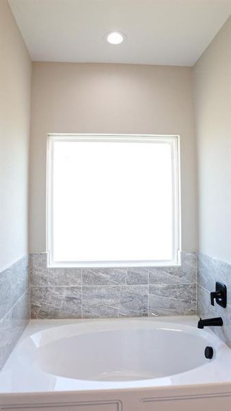 Bathroom featuring a bathing tub and plenty of natural light