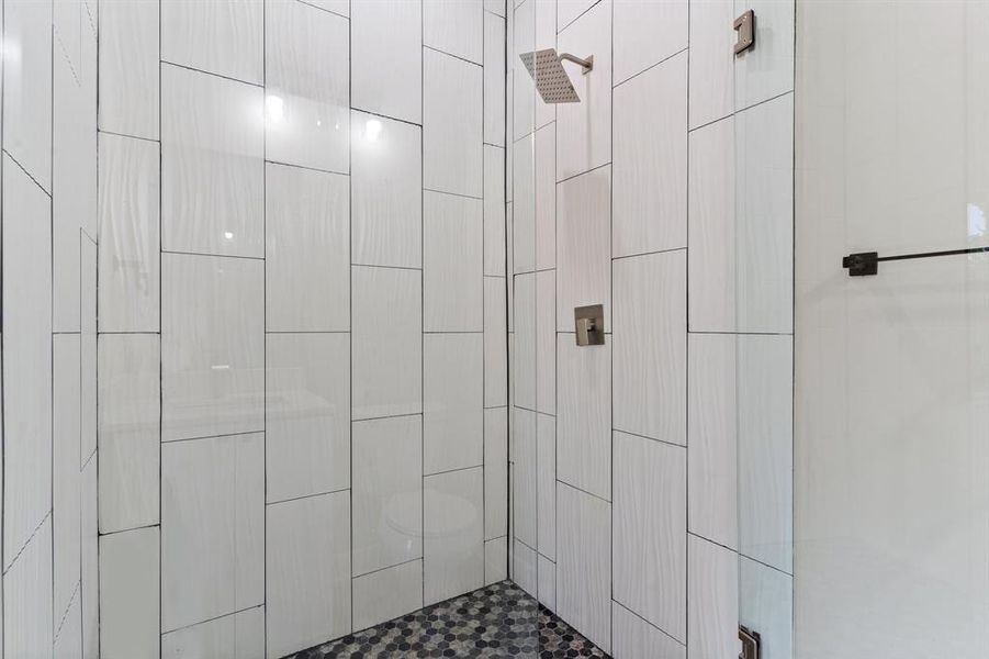 Bathroom featuring tiled shower and toilet