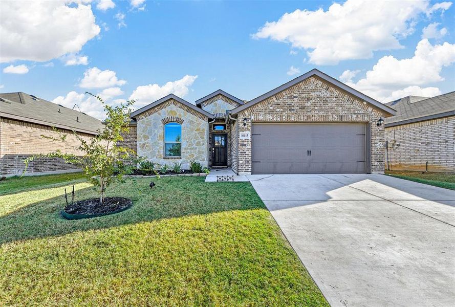 View of front of property with a front yard and a garage