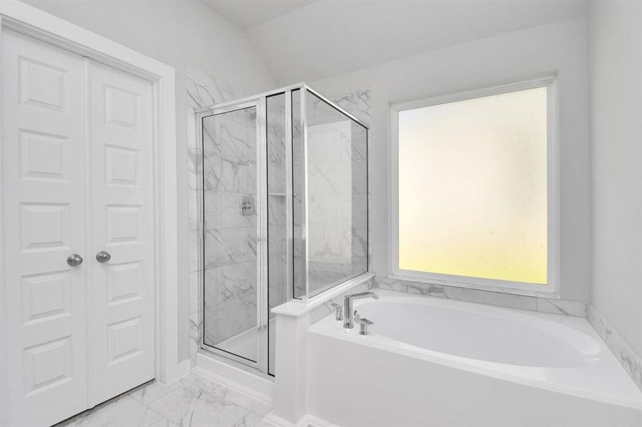 Revel in the expansive walk-in shower surrounded by tasteful tile, unwind in a separate garden tub adorned with personalized detailing. Sample photo of completed home with similar floor plan. Actual colors and selections may vary.