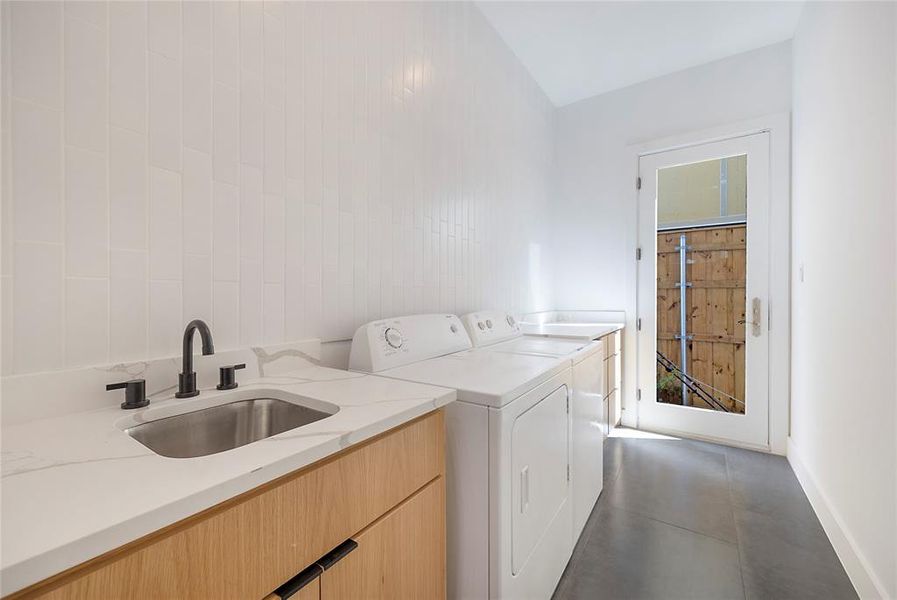 Laundry room with cabinets, sink, and washer and clothes dryer