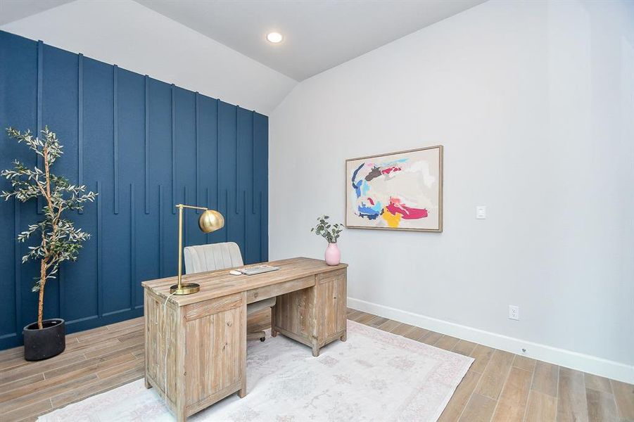 Bright and airy home office space featuring a bold blue accent wall. Large windows provide plenty of natural light, and the room's high ceiling adds a sense of spaciousness.