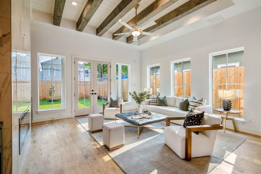 This is your stunning living room with custom beam ceilings and plenty of windows for ample natural light.