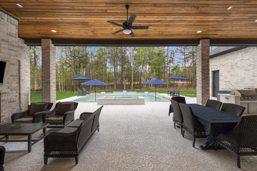 Covered patio with recessed lighting and ceiling fan with a light.