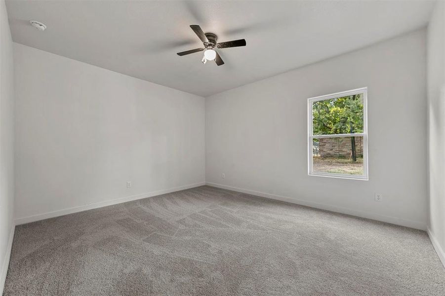 Unfurnished room featuring ceiling fan and carpet flooring