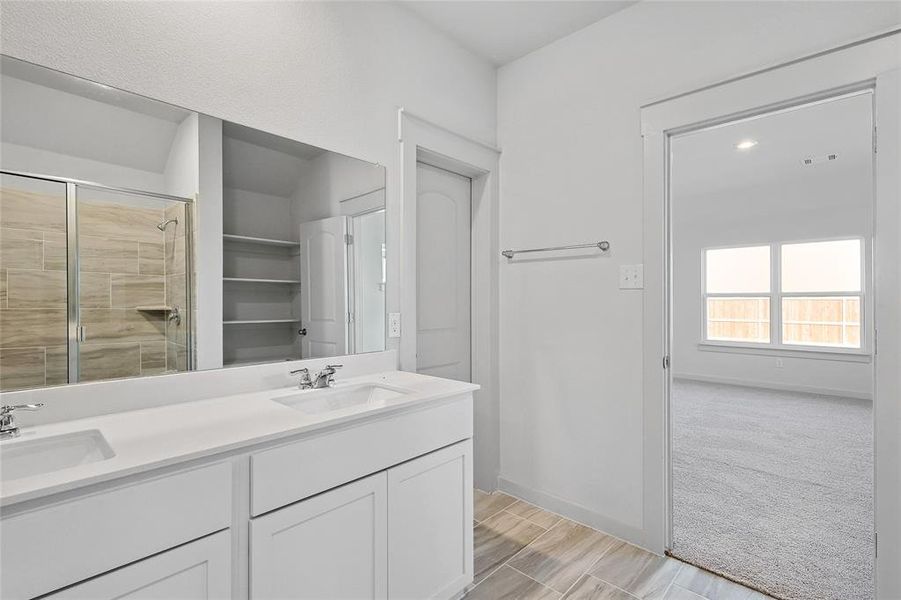 Bathroom with vanity, hardwood / wood-style floors, and a shower with door