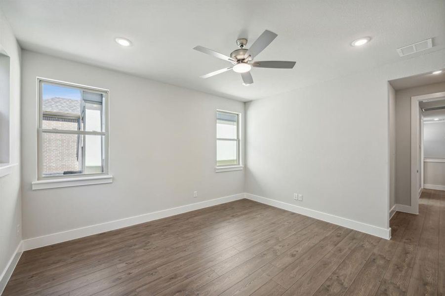 Unfurnished room featuring dark wood-type flooring and ceiling fan