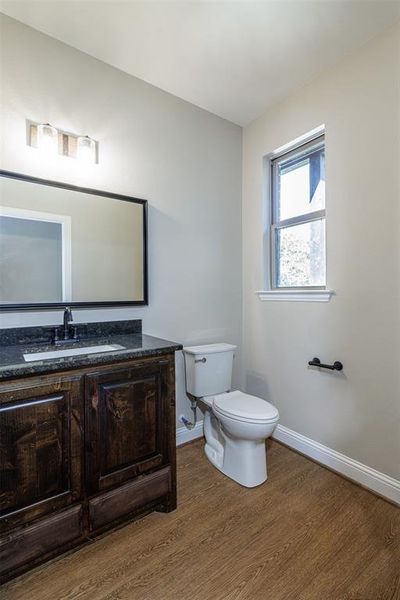 Bathroom with vanity, toilet, and hardwood / wood-style flooring