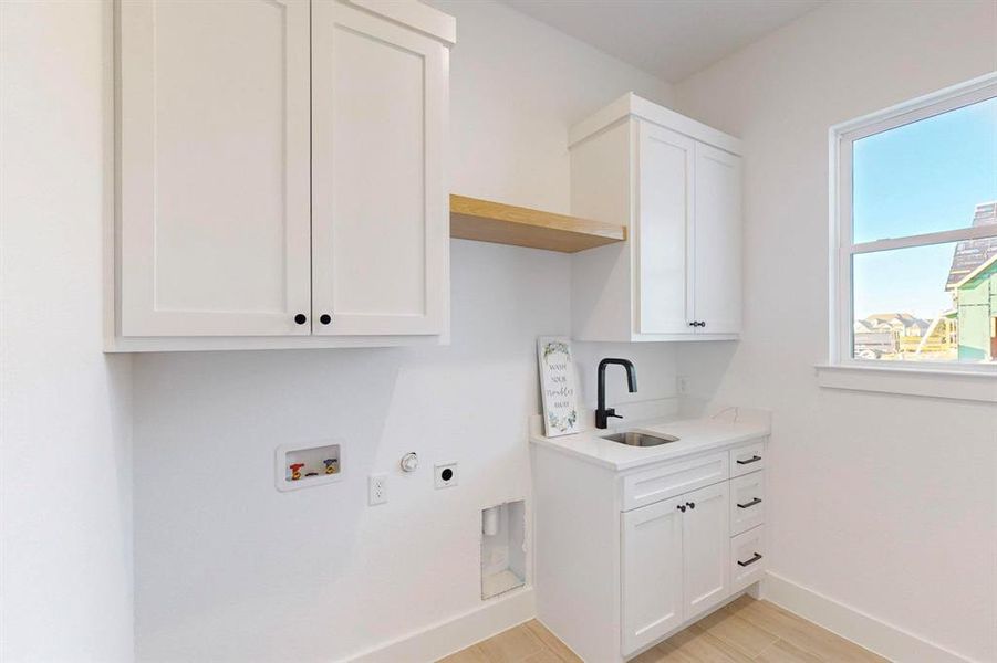 Laundry room with cabinets, light hardwood / wood-style floors, sink, washer hookup, and electric dryer hookup