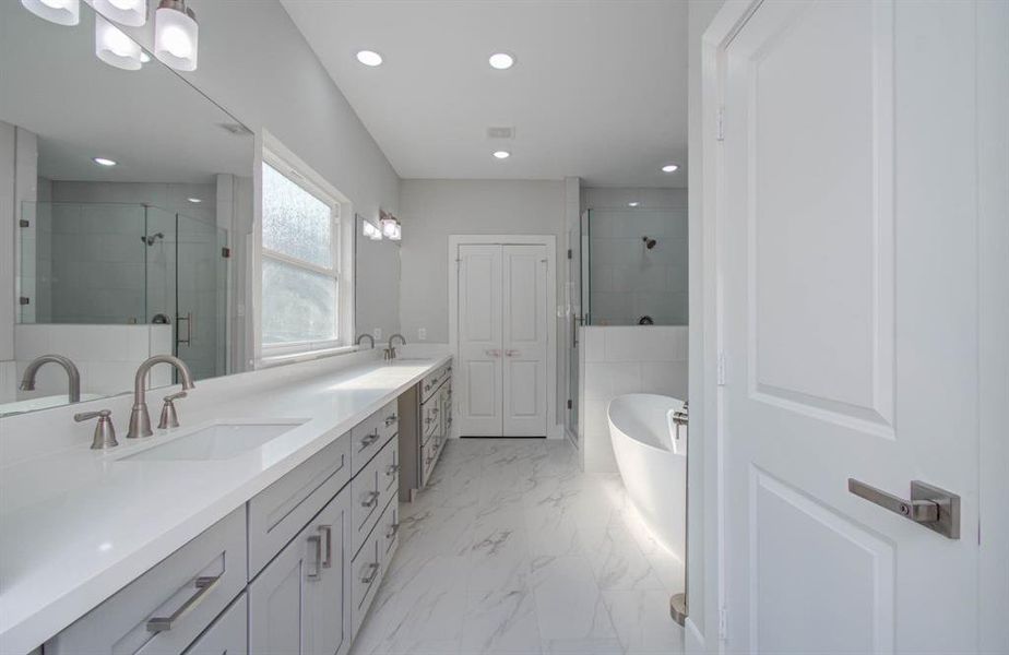 This expansive master ensuite bathroom has granite countertops and natural lighting