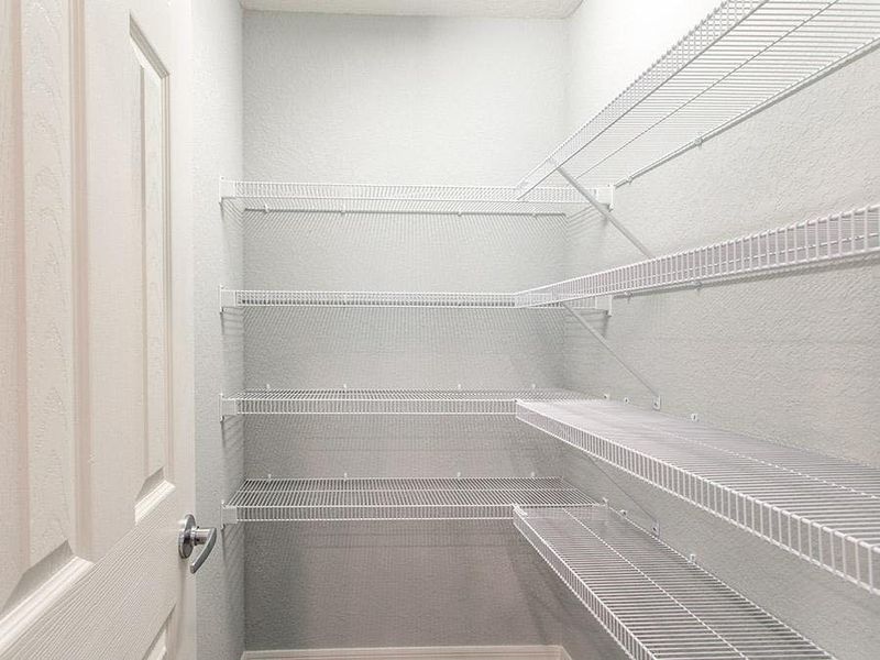 Walk-in pantry with tight mesh shelving - Photo showcases a home with similar finishes. Colors and design options in actual home for sale may differ.