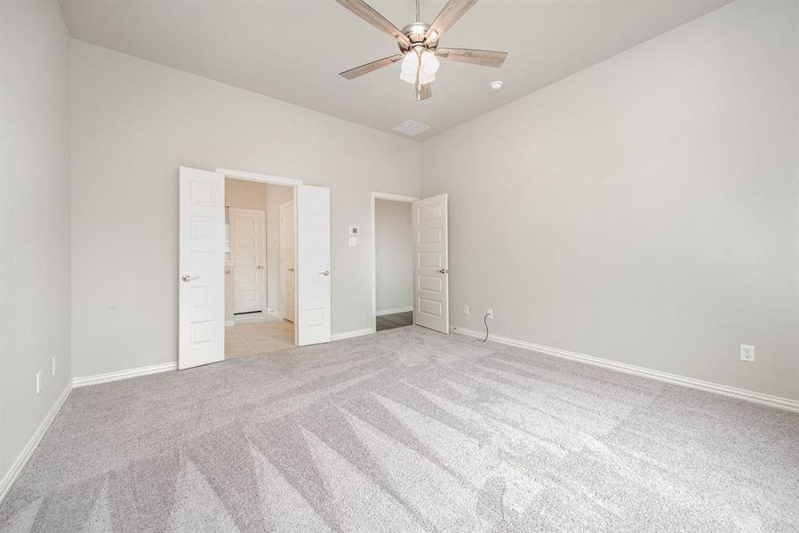 Unfurnished bedroom featuring light carpet and ceiling fan