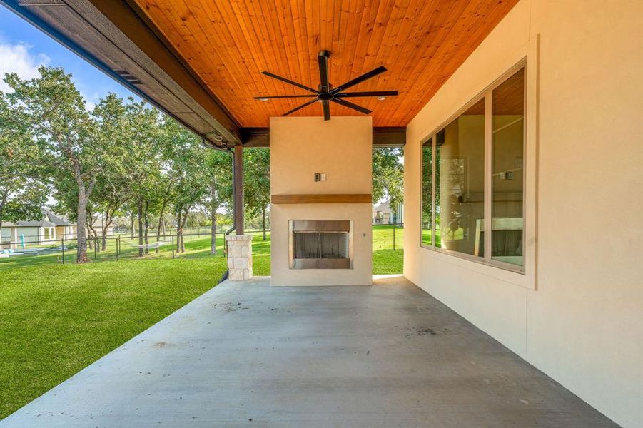 View of patio featuring an outdoor fireplace and ceiling fan
