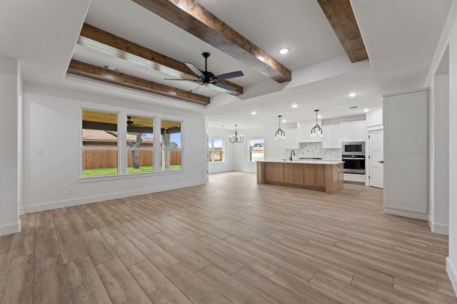 living room featuring beamed ceiling, ceiling fan