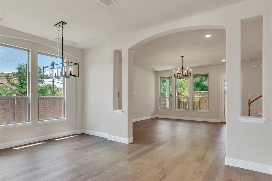 Unfurnished room with a notable chandelier and light wood-type flooring