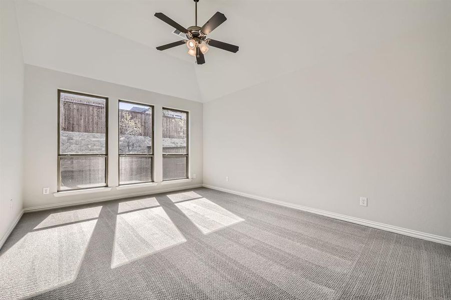 Unfurnished room featuring carpet, high vaulted ceiling, and ceiling fan