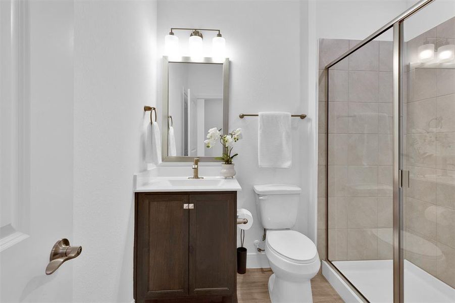 Full secondary bathroom with shower, framed mirror, and upgraded plumbing fixtures.
