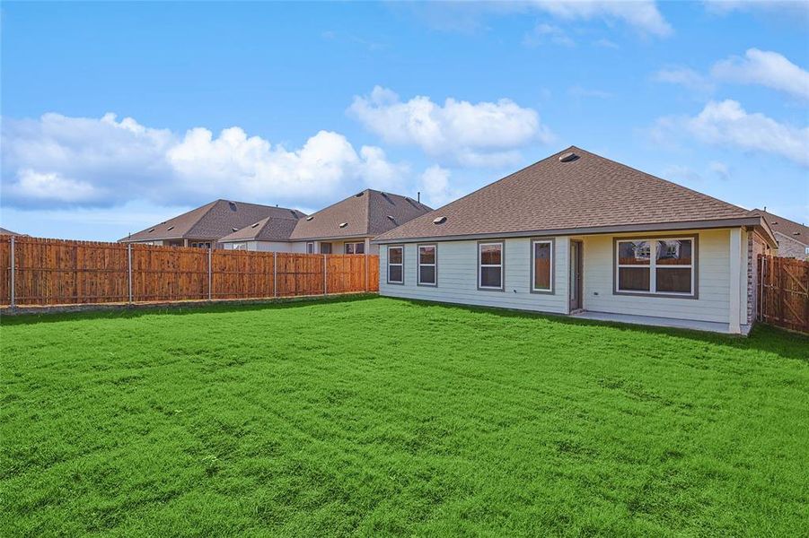 Back of house featuring a yard