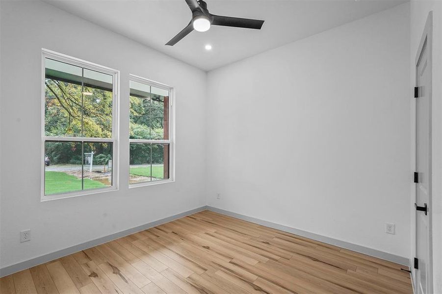 Unfurnished room with ceiling fan and light hardwood / wood-style flooring