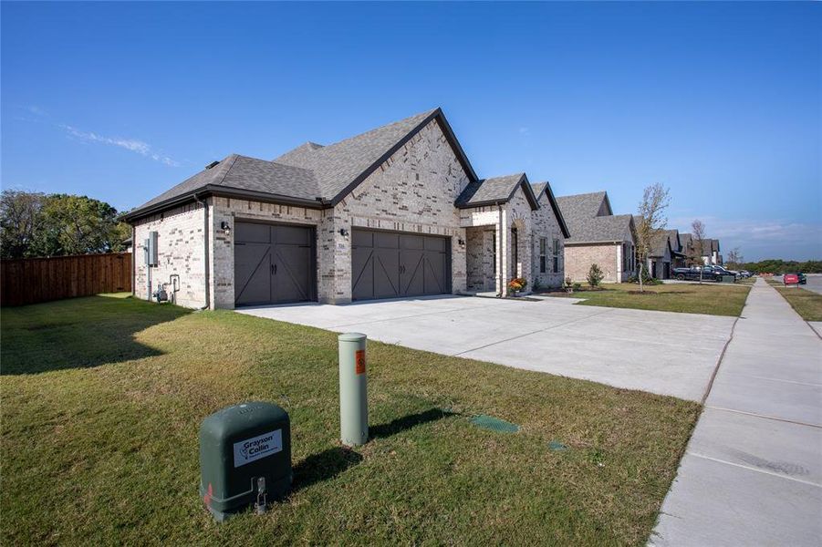 View of front facade featuring a front yard and a garage