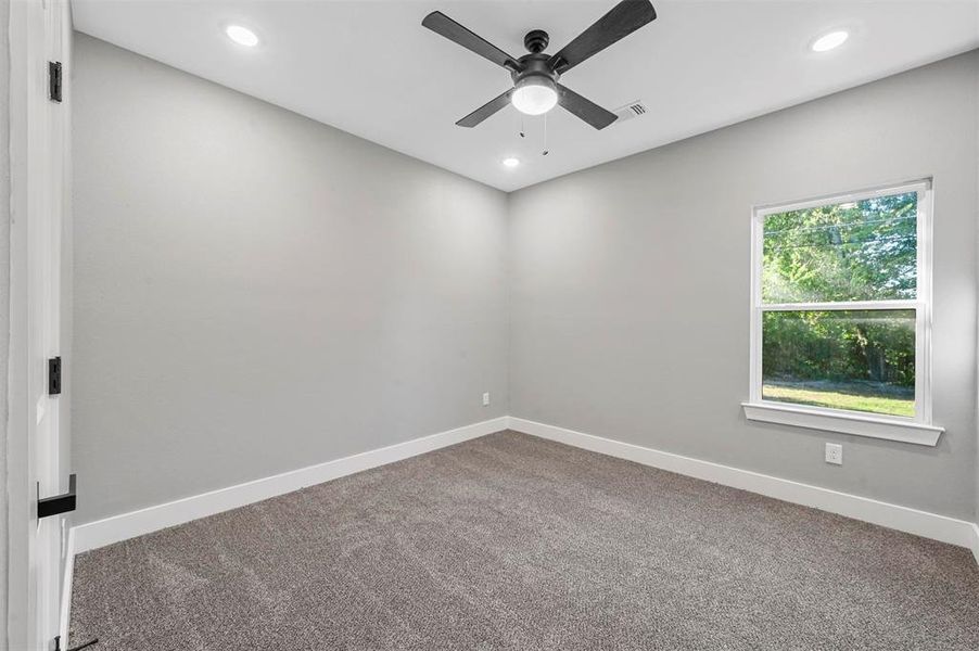 Empty room featuring ceiling fan and carpet floors