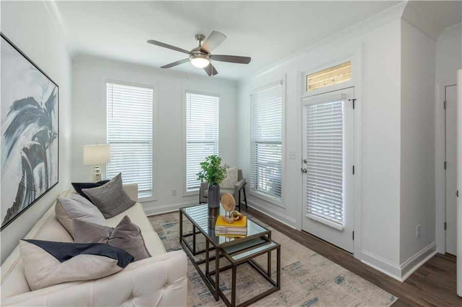 Sun  room with wood-type flooring, ceiling fan, crown molding, and a healthy amount of sunlight , opens up to a double wooden decks , not the actual unit