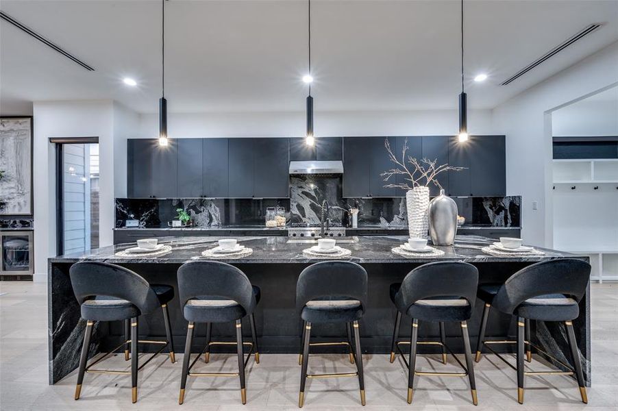 Kitchen with decorative backsplash, decorative light fixtures, and dark stone counters