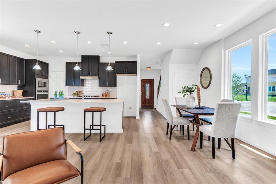 Kitchen featuring plenty of natural light, decorative backsplash, appliances with stainless steel finishes, and light hardwood / wood-style floors