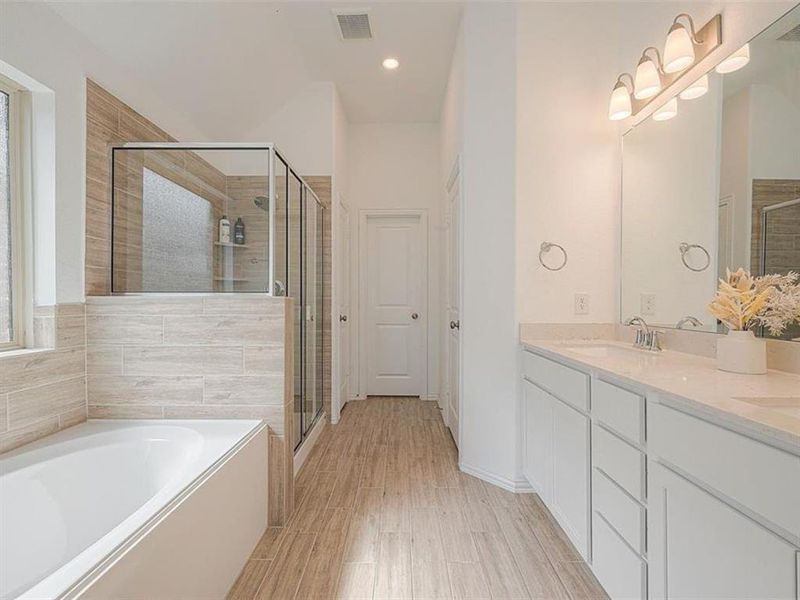 This bathroom offers a spa-like experience with a deep soaking tub and a separate walk-in shower.