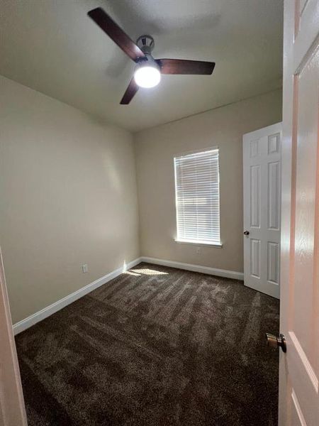 Carpeted empty room with ceiling fan