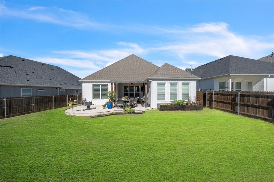 Rear view of property with a patio and a yard