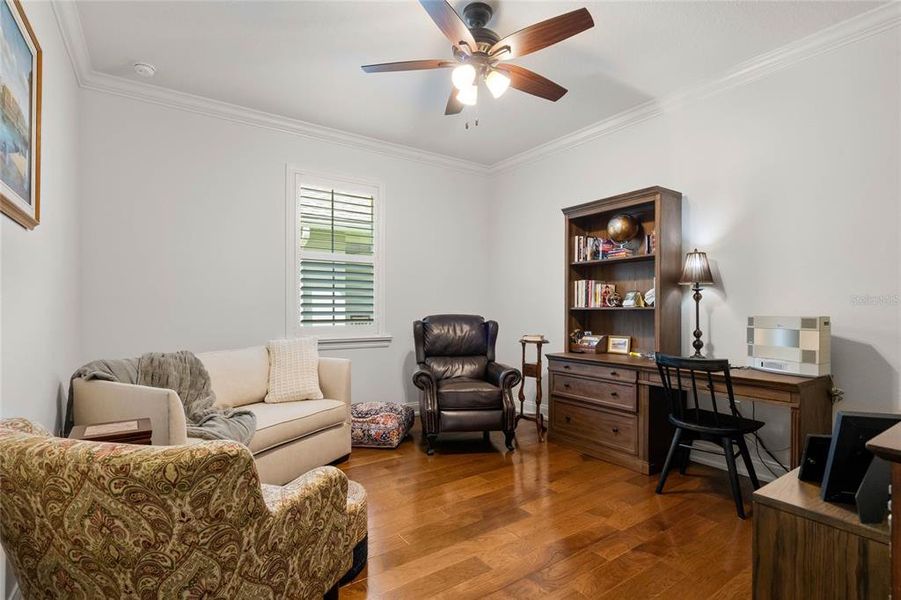 Office/ Flex Room features Plantation Shutters, Wood Flooring and Crown Molding