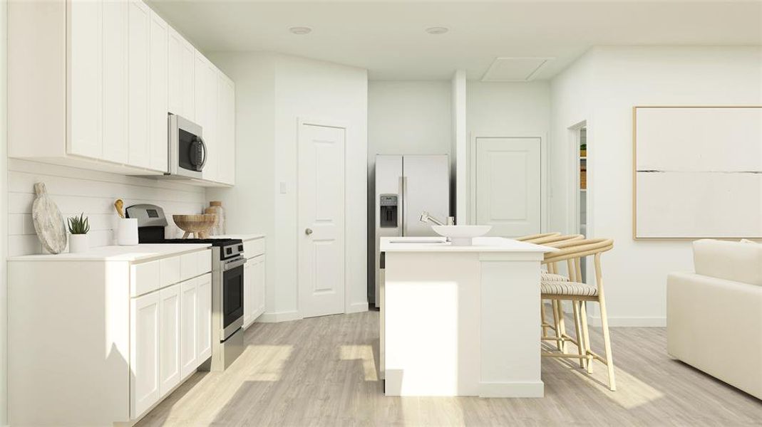 Kitchen featuring light hardwood / wood-style flooring, an island with sink, white cabinets, a kitchen bar, and appliances with stainless steel finishes