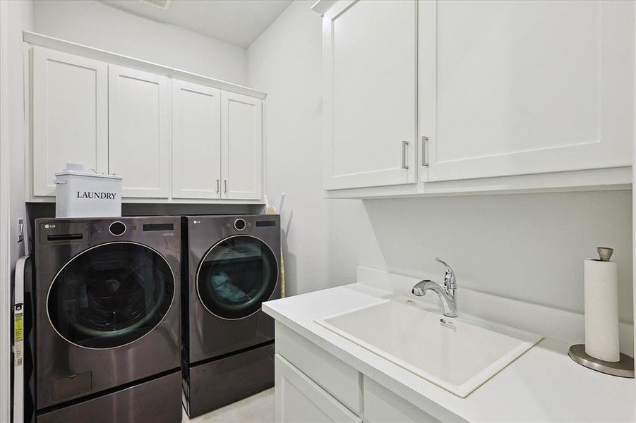 Laundry room with cabinets, sink, and washer and dryer