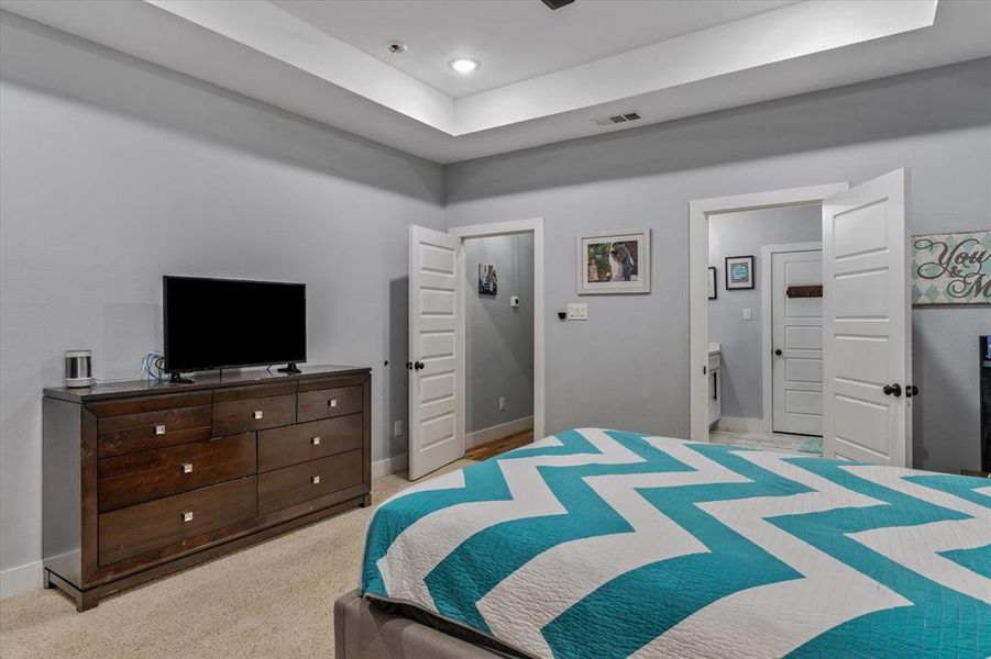 Carpeted bedroom featuring ensuite bathroom