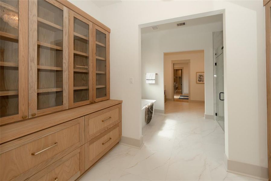 Step into your primary bath with a linen closet and mirror.