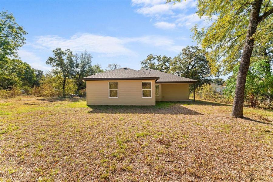 Rear view of property with a yard