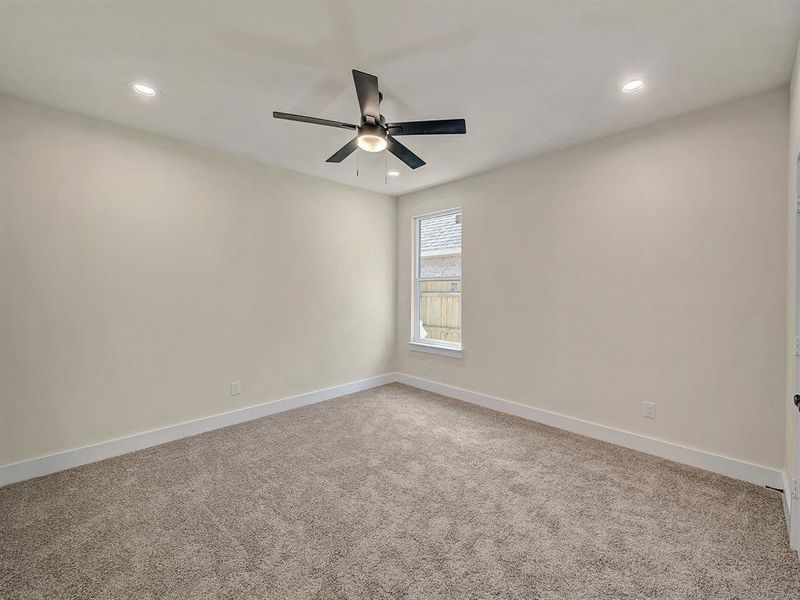 Carpeted spare room with ceiling fan