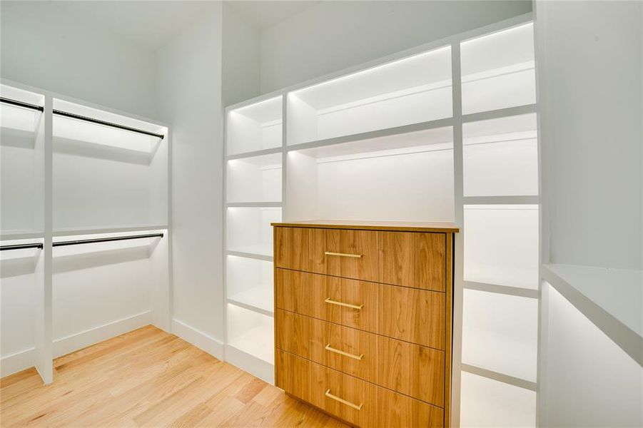 Spacious closet with light hardwood / wood-style flooring