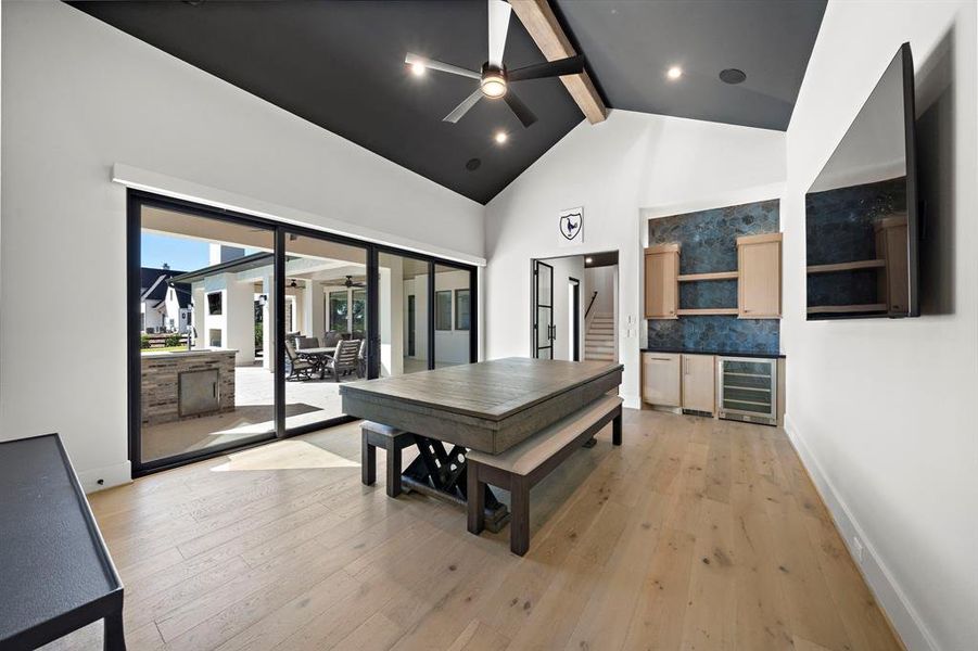 Modern Glass and Metal Doors adorn the Game Room. Additionally featuring Vaulted Ceilings with Faux Wood Beams , Built-in Nugget Ice Maker Machine, Atmos Speaker, views and access to the outdoor oasis.