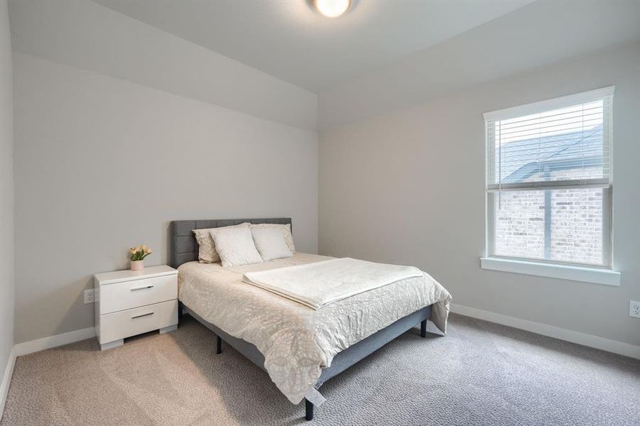 Bedroom featuring multiple windows and light colored carpet