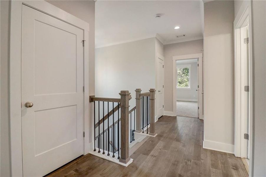 Corridor with ornamental molding and light hardwood / wood-style flooring