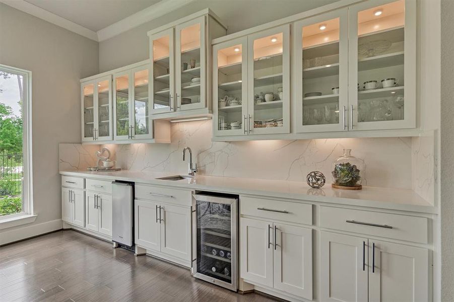 Built-in Butler's pantry comes equipped with wine fridge, rinse sink, ice maker, stunning quartz countertops and glass front display cabinets with elegant LED lighting.