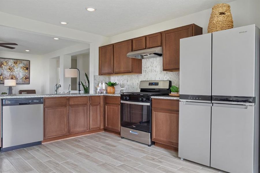 This kitchen will not disappoint! Your family and guests will enjoy many nights of fun, food and entertainment with ample counter space for setting up a wonderful array of provisions! This view of this gorgeous kitchen showcases SS appliances, granite countertops, beautiful tile backsplash, gas range, high ceiling, recessed lighting and tile floors!