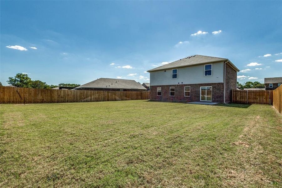 Back of house with a patio area and a yard