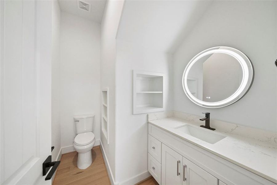 Elegantly illuminated, roomy guest bathroom.